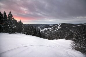 A snowy mountain landscape with a clear sky and distant hills. - Hôtel Stoneham (Stoneham-et-Tewkesbury)