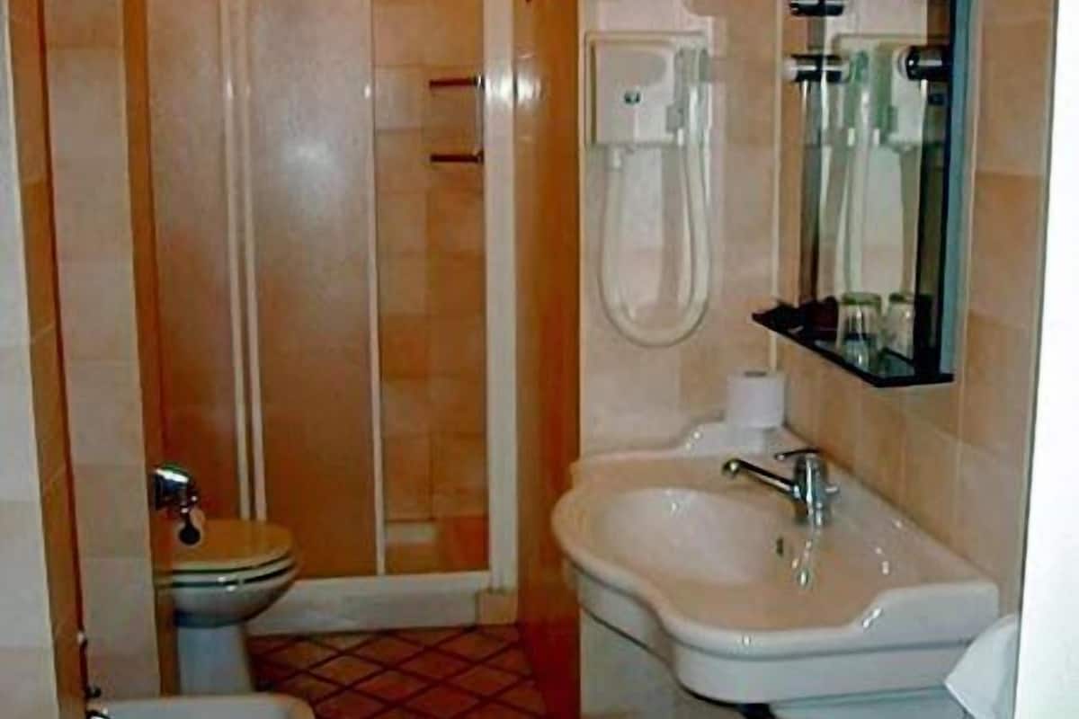Een badkamer met toilet, bidet en douchecabine.