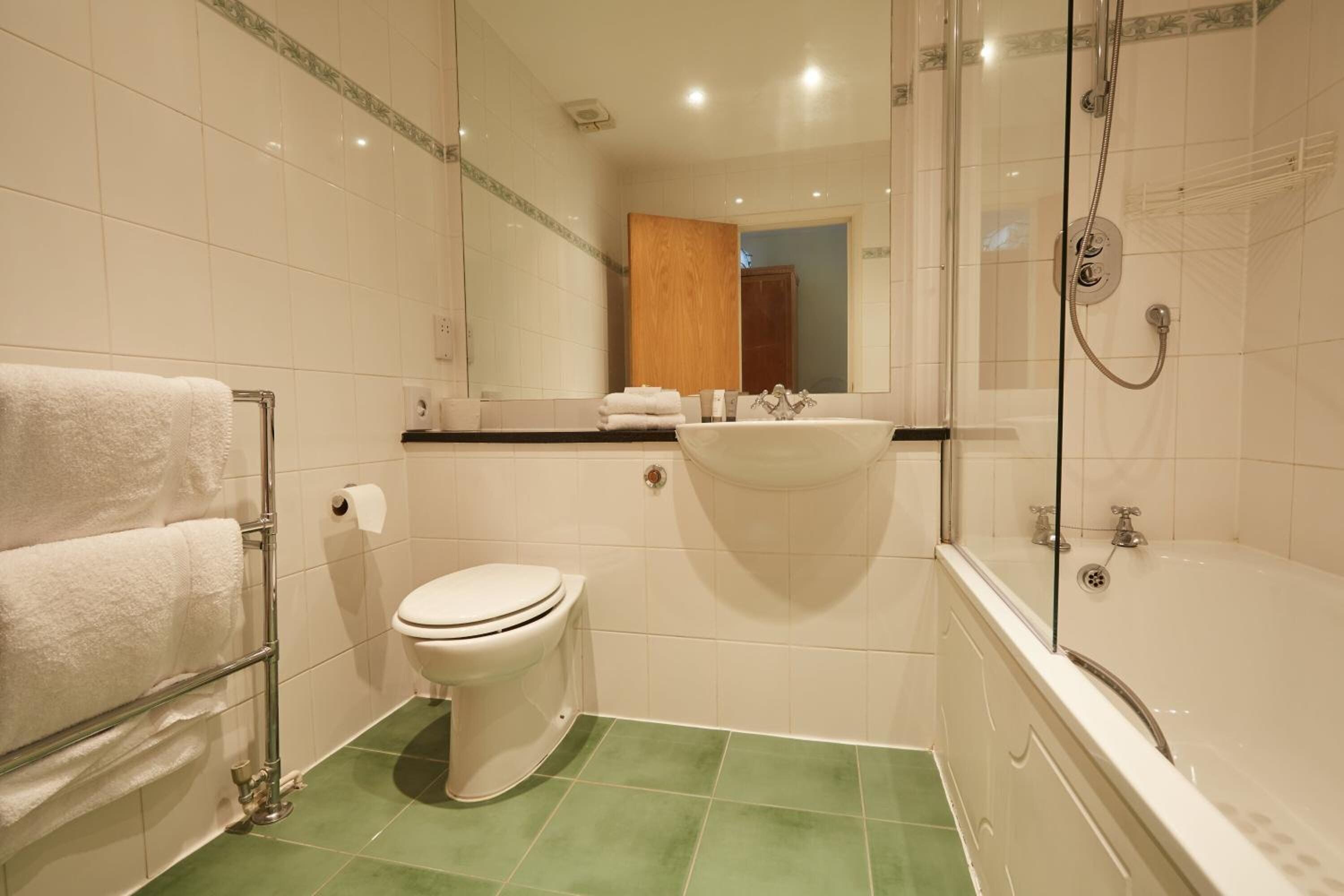A bathroom with a toilet, sink, and bathtub.