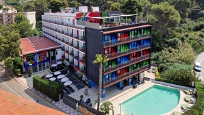A multi-story hotel with balconies, a pool, and a view of the surrounding hills. - Lloret Vibe Affiliated by FERGUS (Lloret de Mar)