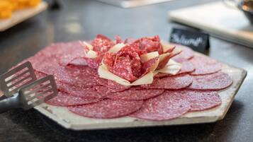 Un plato de salami y queso en rodajas sobre una fuente de cerámica.