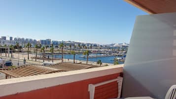 A balcony with a view of a marina and city skyline.