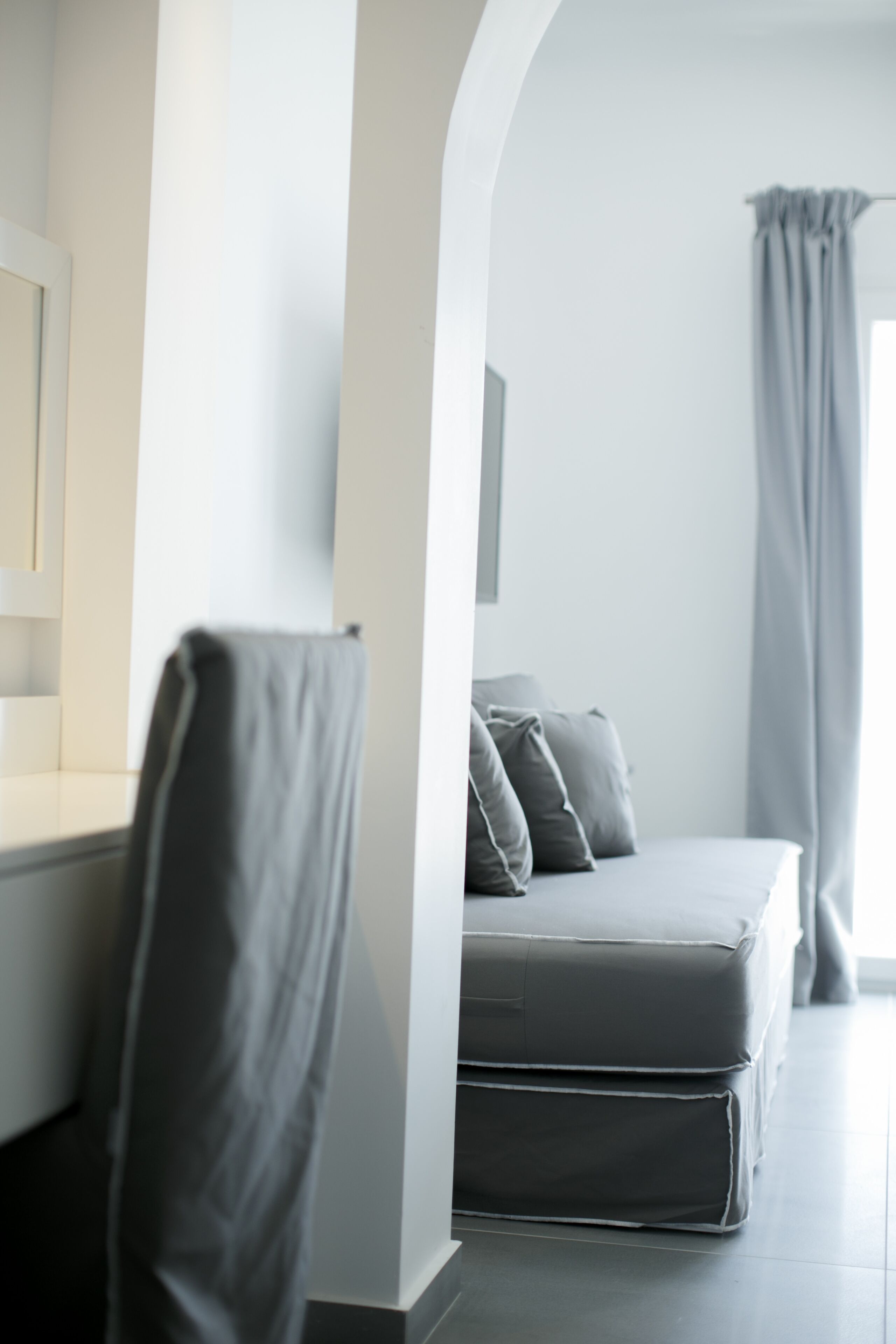 A modern bedroom with a bed, a chair, and a desk.