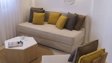Una sala de estar moderna con un sofá, una silla de madera y una mesita de centro.