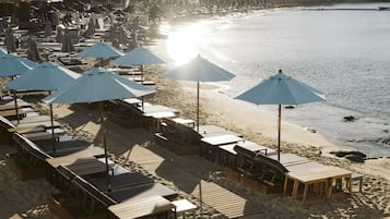 A beachside resort with wooden deck seating and umbrellas.