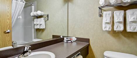 A bathroom with a sink, mirror, towel rack, and toilet.