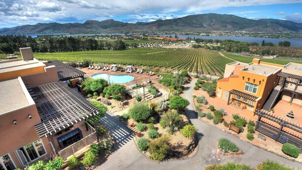 A hotel with a pool, outdoor seating, and a view of vineyards and mountains. - Spirit Ridge, in The Unbound Collection by Hyatt (Osoyoos)