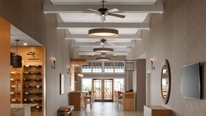 A spacious hotel lobby with a wine cellar, a reception desk, and a large mirror. - Spirit Ridge, in The Unbound Collection by Hyatt (Osoyoos)