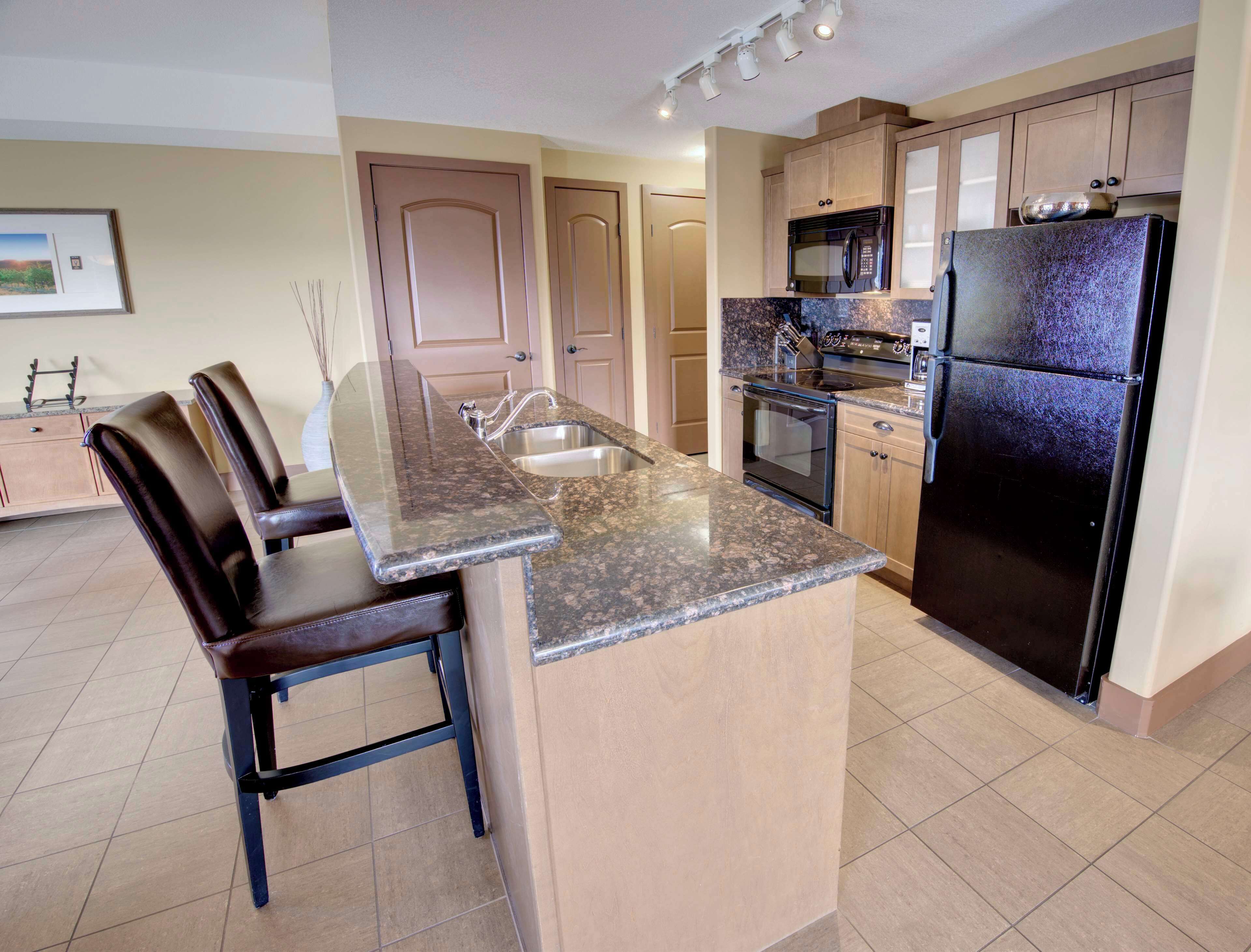 A kitchen with a granite countertop, stainless steel appliances, and wooden cabinets.