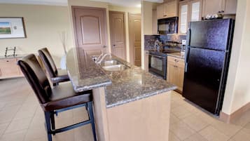 A kitchen with a granite countertop, stainless steel appliances, and wooden cabinets.