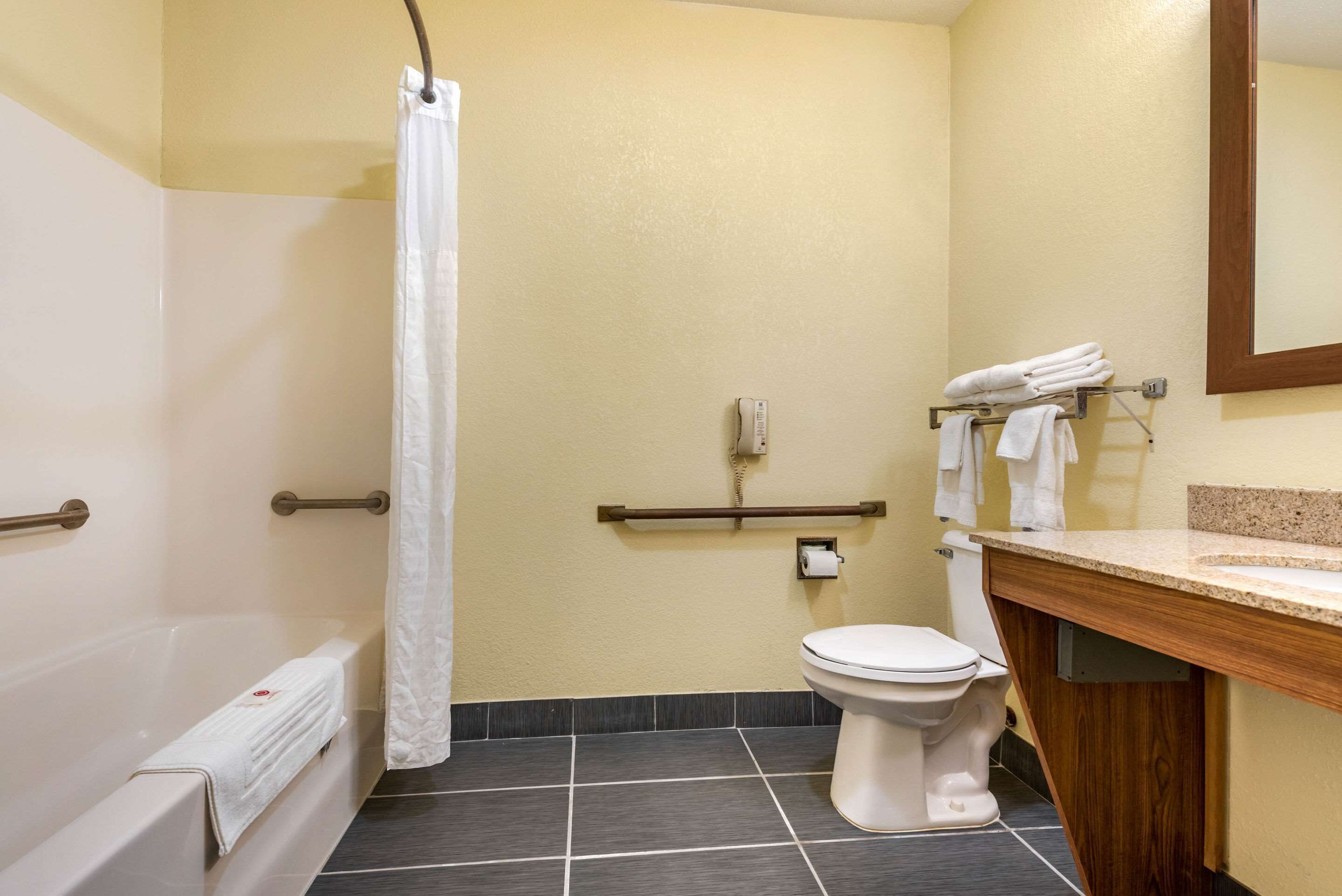 Une salle de bain avec une baignoire, des toilettes et un rideau de douche.
