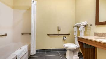 Une salle de bain avec une baignoire, des toilettes et un rideau de douche.