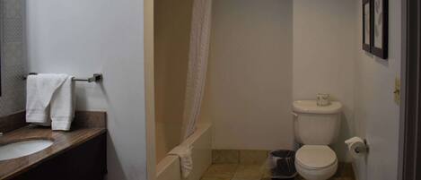 A bathroom with a sink, toilet, and shower.