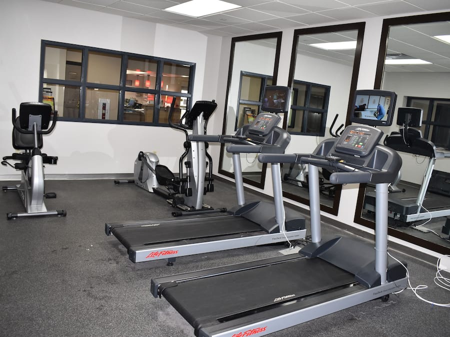 A gym with treadmills, stationary bikes, and exercise equipment.