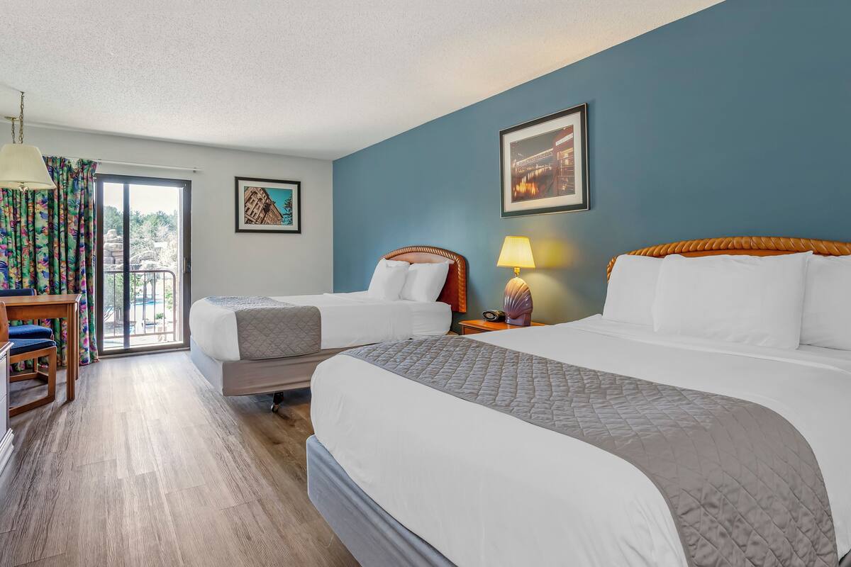Una habitación de hotel con dos camas, un escritorio y una silla.