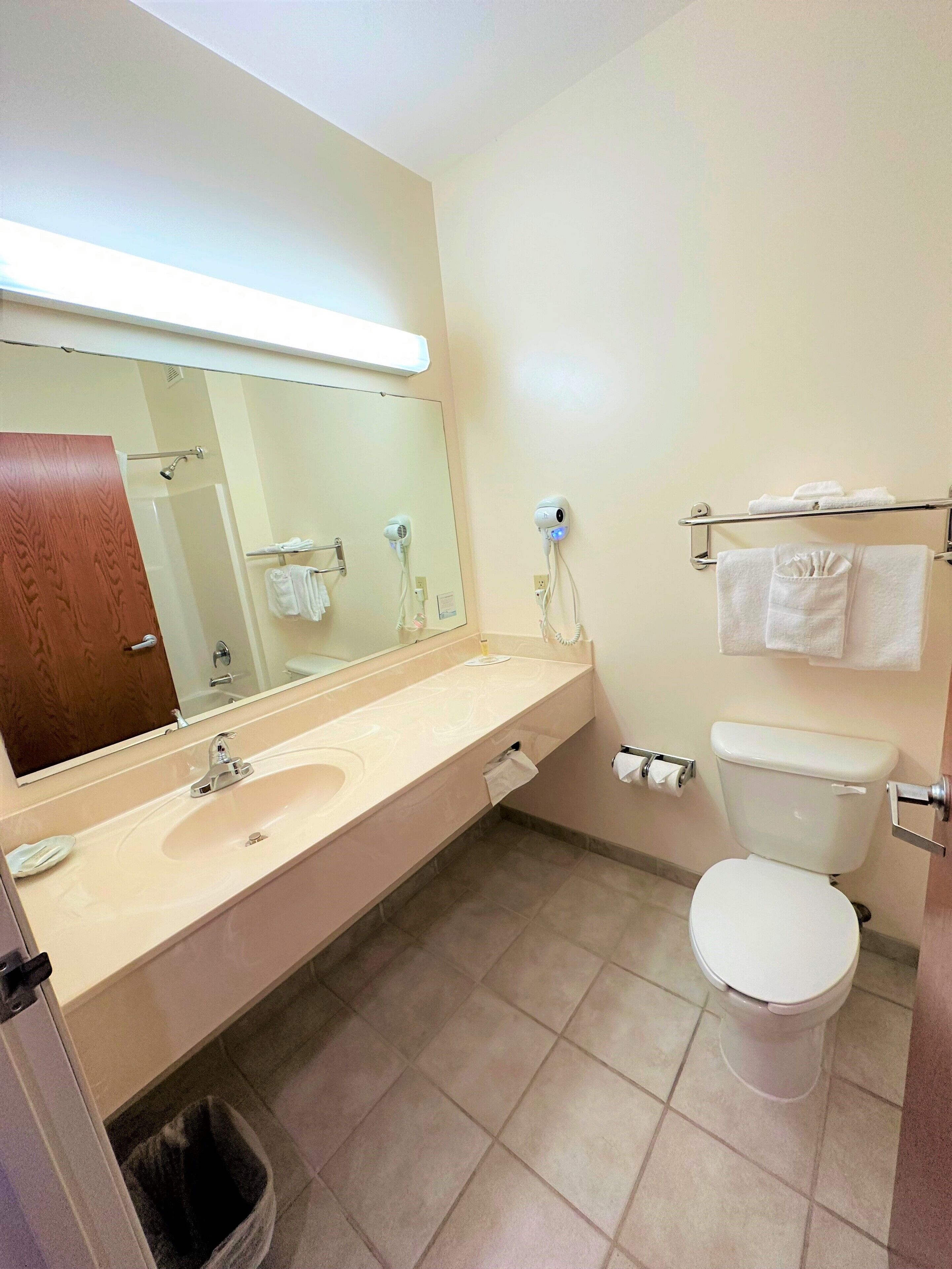 Une salle de bain équipée d’un lavabo, d’un miroir, d’un porte-serviettes et de toilettes.