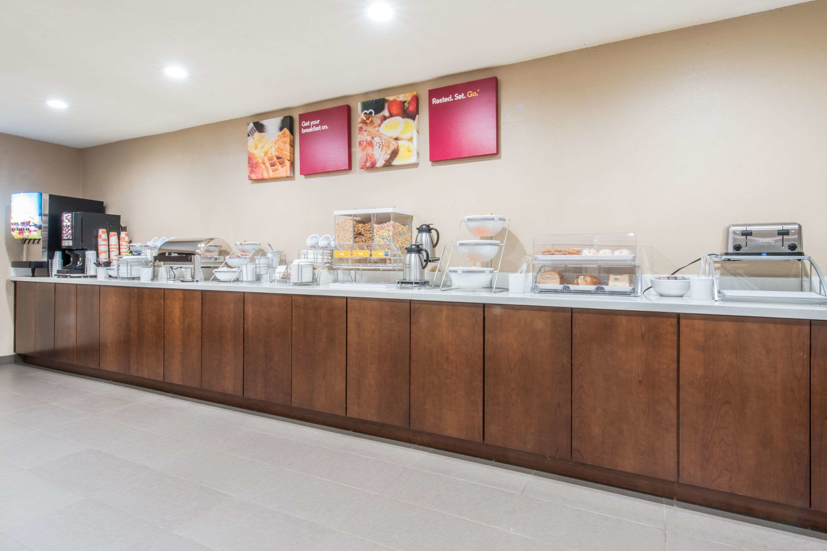 A buffet counter with various food items and a coffee station.