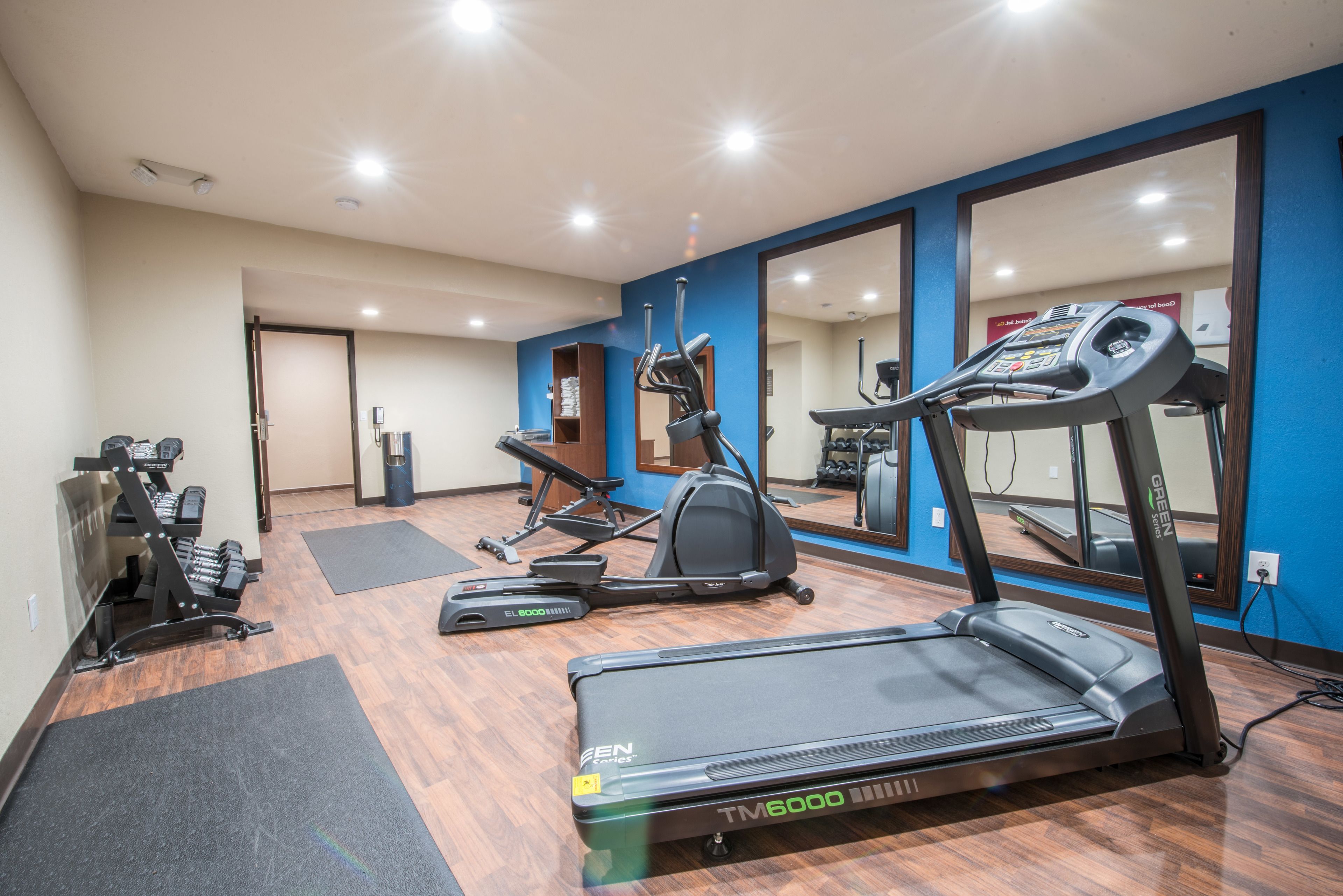 Een sportschool met loopbanden, elliptische trainers en gewichten.