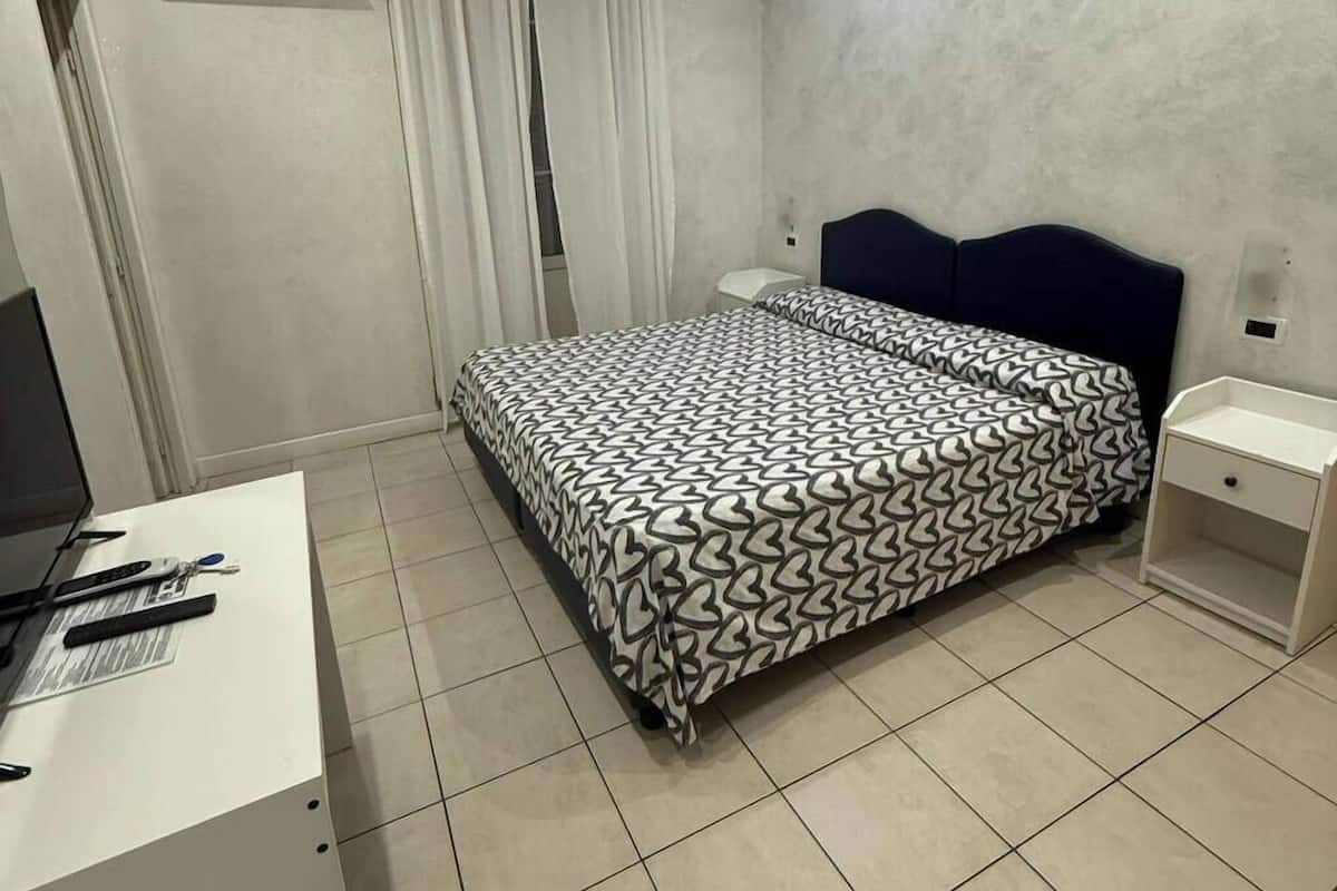 Un dormitorio con cama, escritorio y silla.