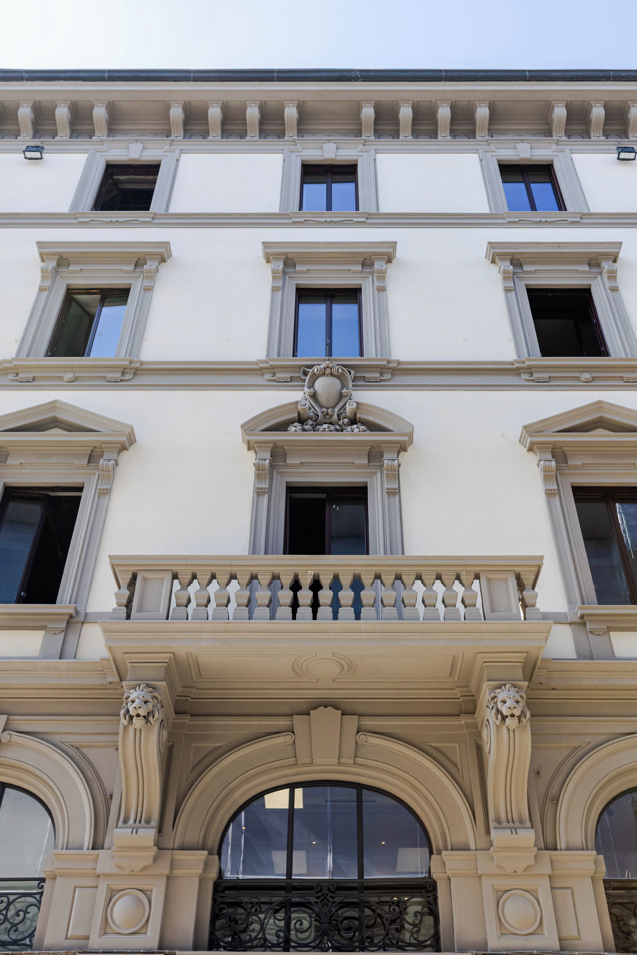 A building with a classical architectural style, featuring a central balcony with ornate balustrades and decorative columns.