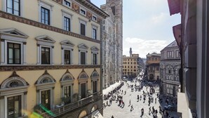 A historic square with classical architecture, including ornate facades and a prominent tower.
