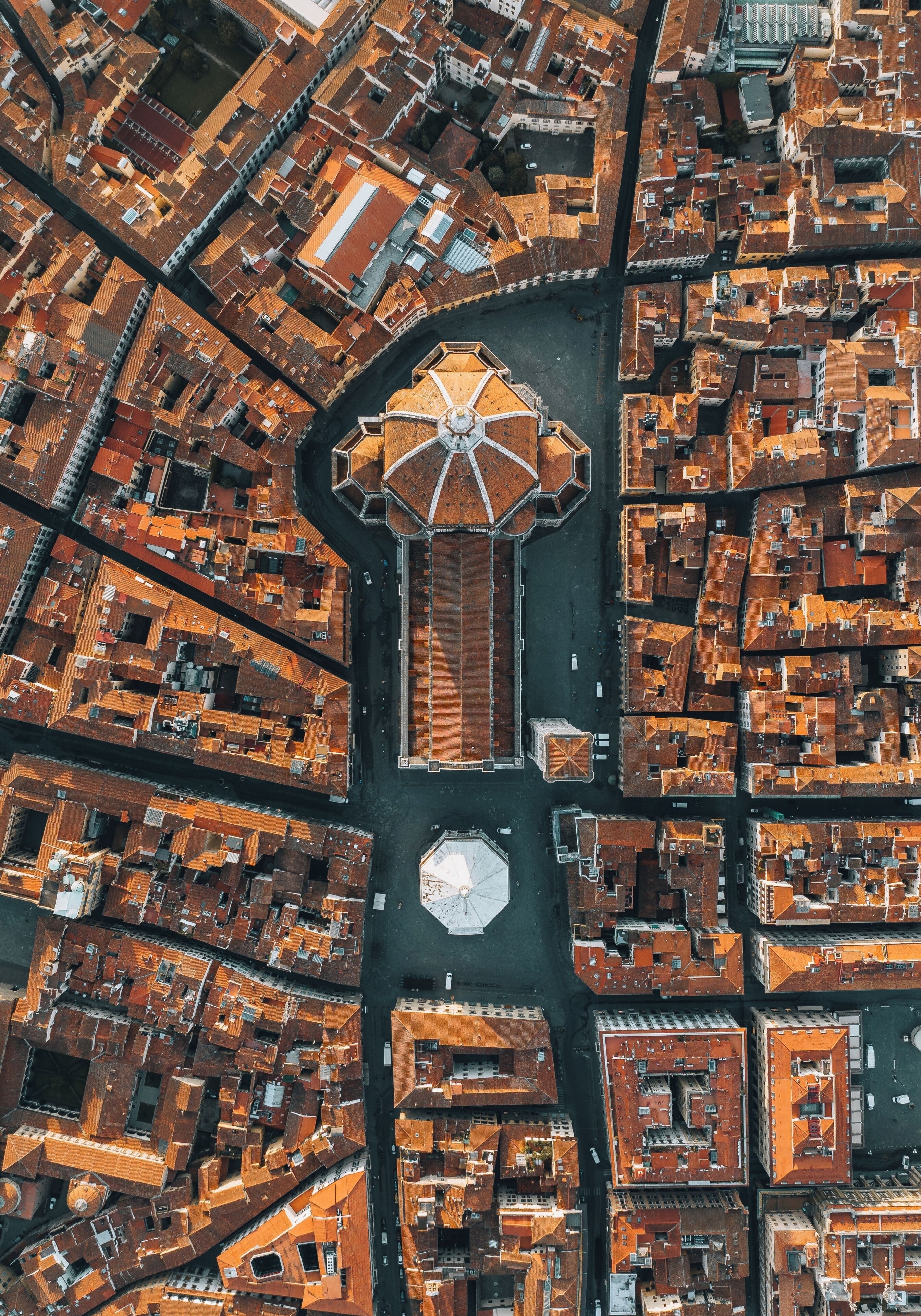 Eine Vogelperspektive einer Stadt mit einem markanten, achteckigen Gebäude mit Kuppel, umgeben von einem Straßennetz und Bauten.