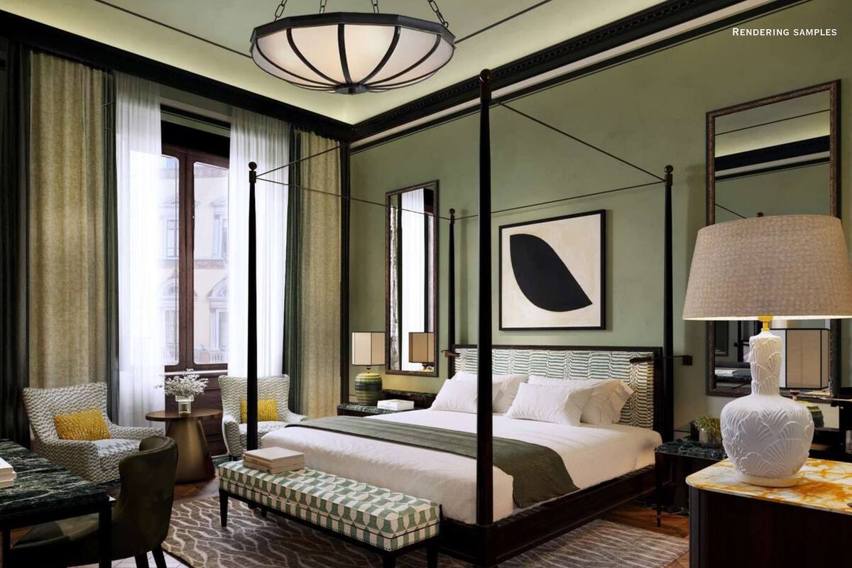 A spacious bedroom with a four-poster bed, a large mirror, and a modern chandelier.