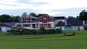 A large, modern house with multiple levels, large windows, and a well-maintained lawn. - Castlerosse Park Resort (Killarney)