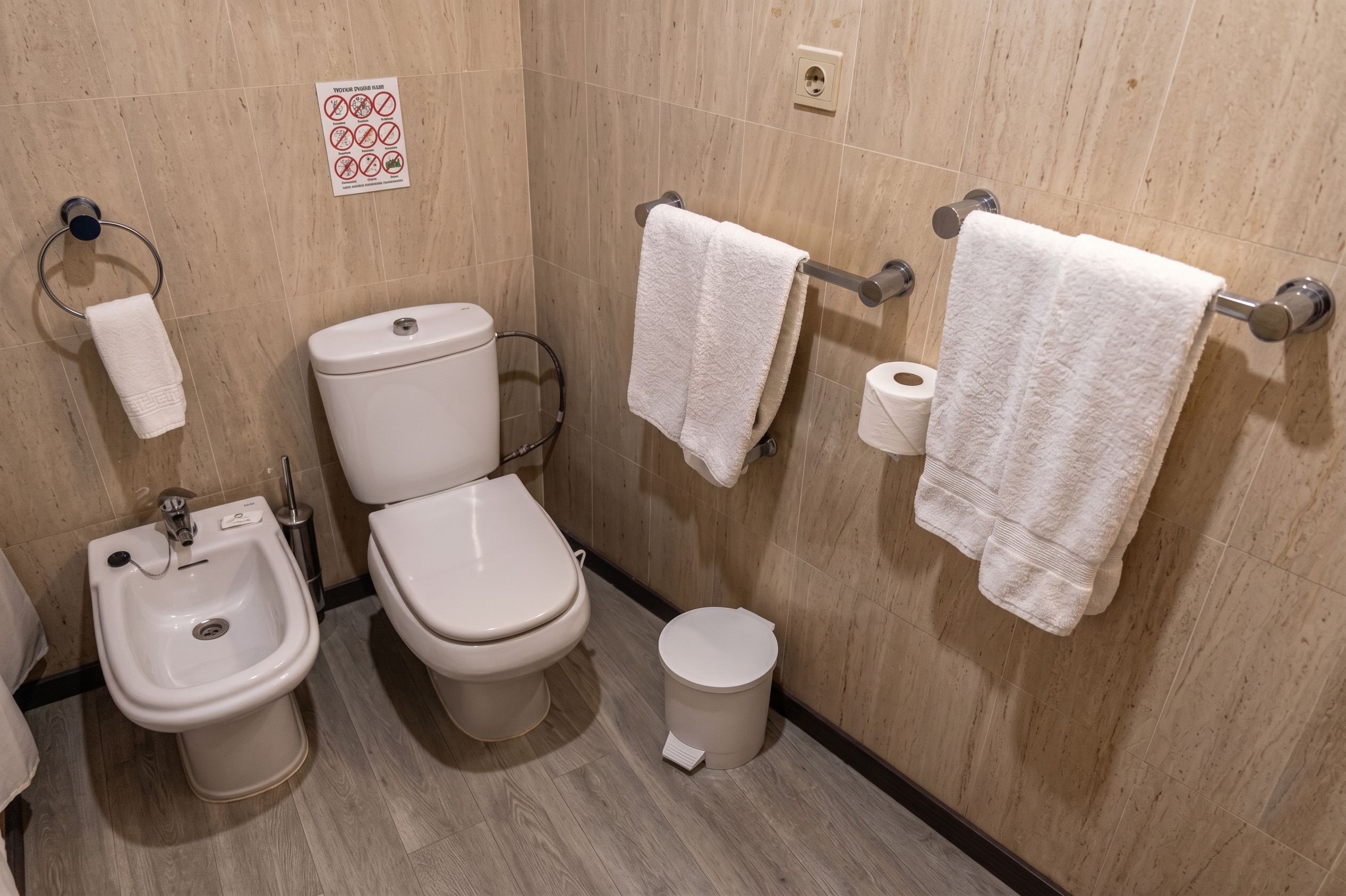 Un baño con bidé, inodoro y lavamanos.