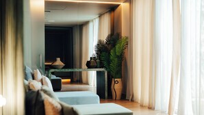 Een moderne woonkamer met een bank, een salontafel en een potplant.