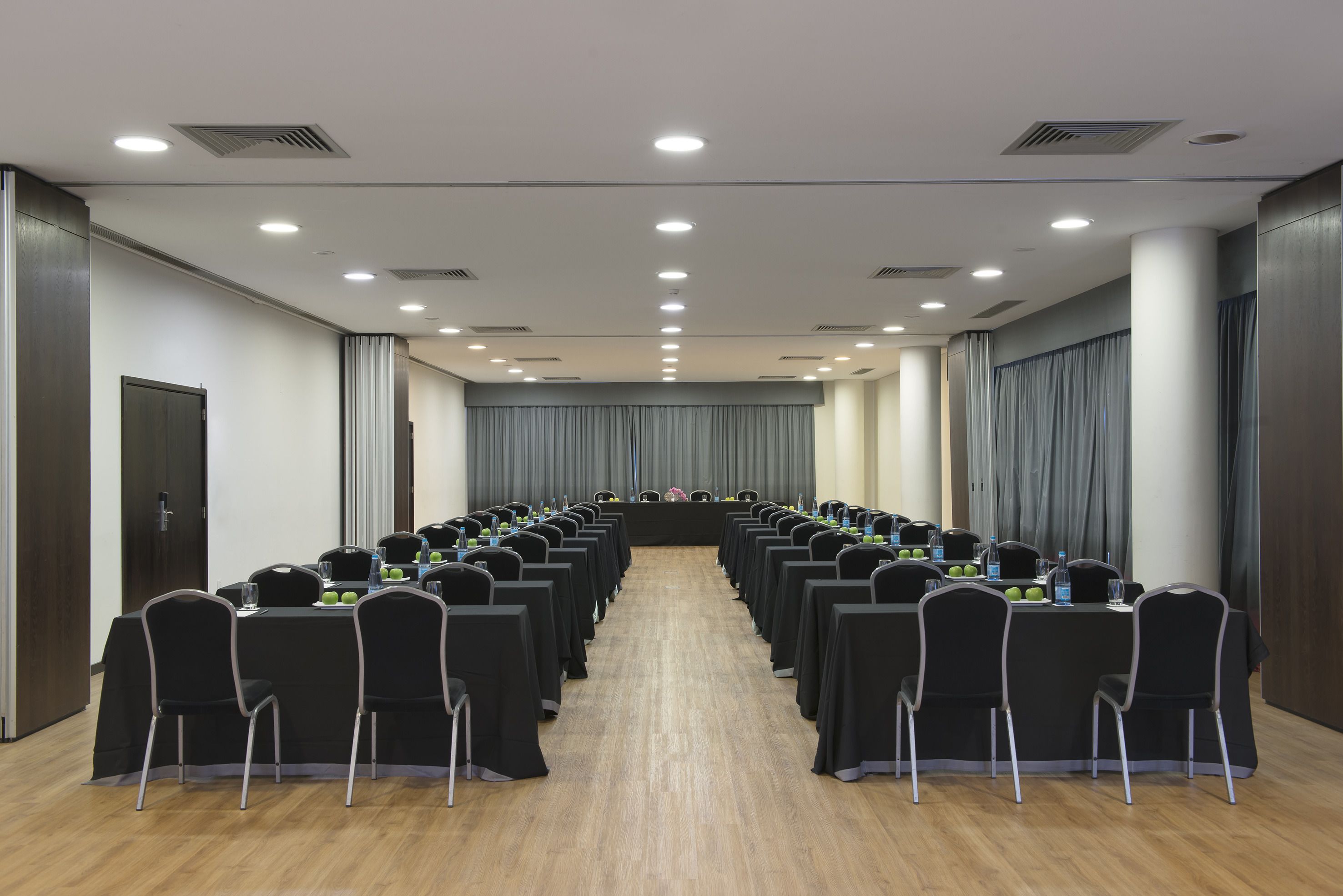 A conference room with a long table, chairs, and a podium.