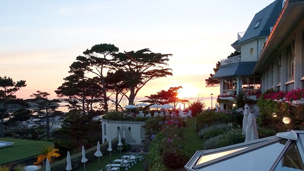 A resort with a pool, sun loungers, and a large tree in the foreground. - TI AL LANNEC Hotel - Restaurant & Spa (Trébeurden)