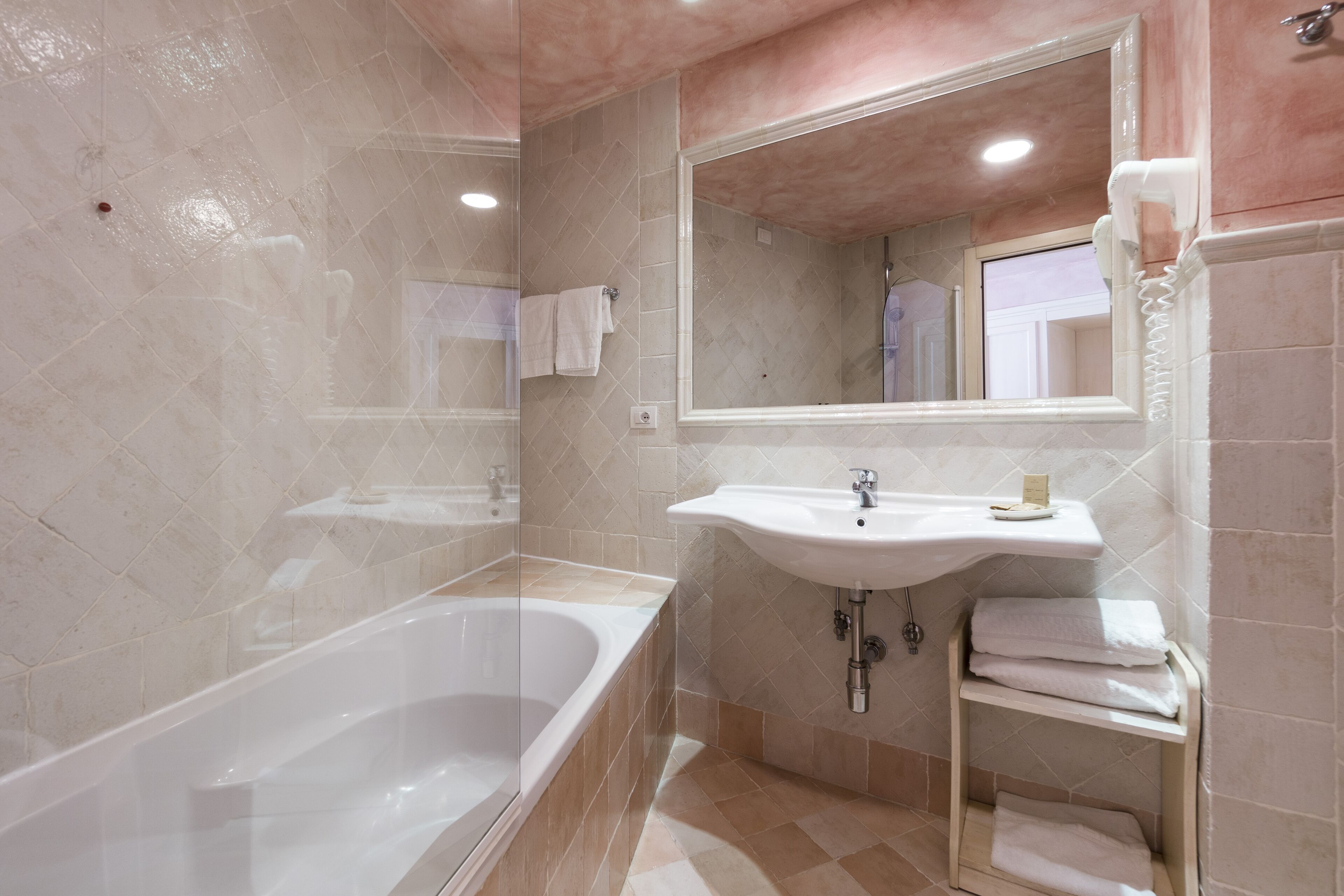 Ein Badezimmer mit Badewanne, Waschbecken und Spiegel.