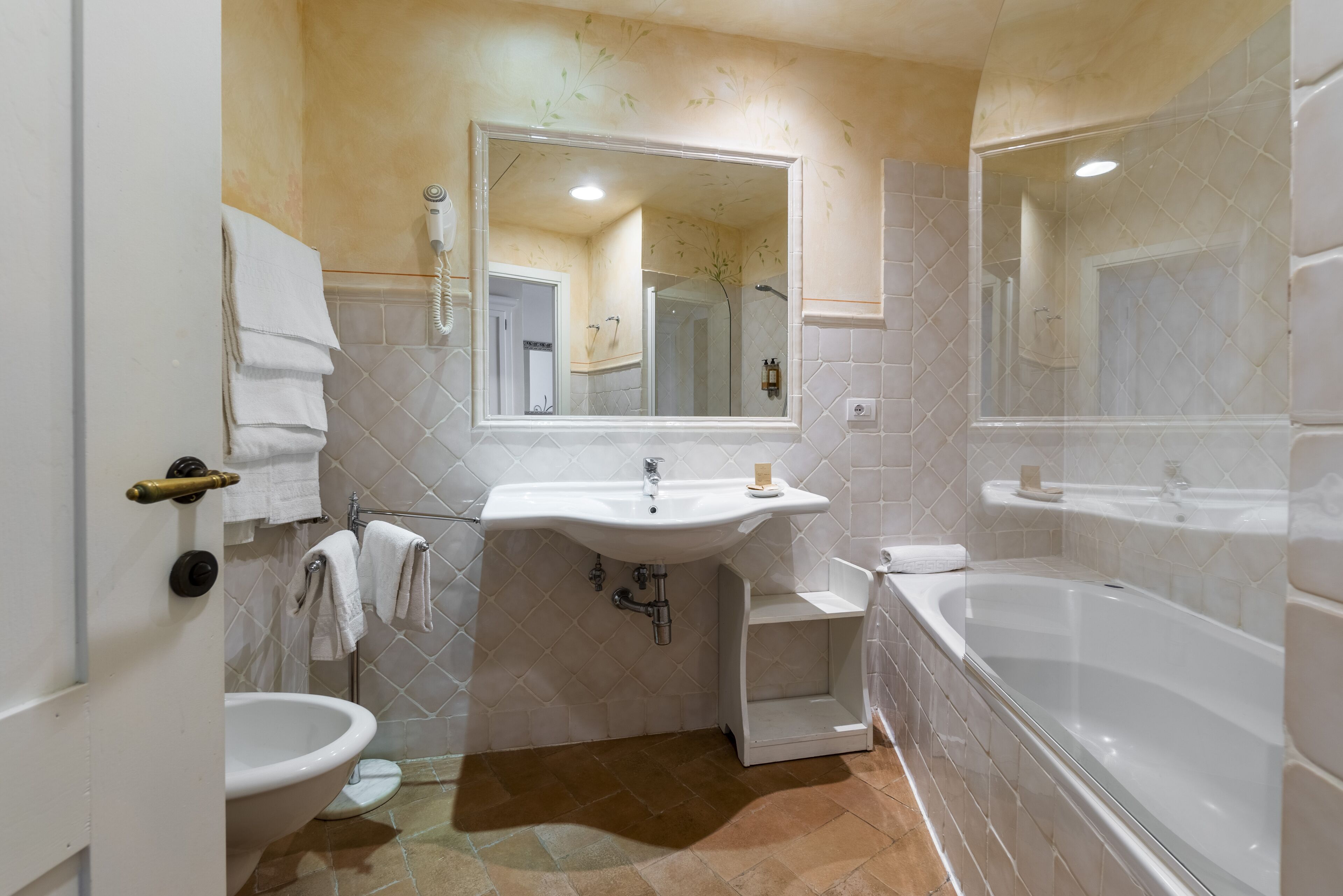 Un baño con lavamanos, inodoro y bañera.
