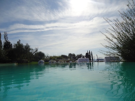 Una piscina al aire libre de temporada, sombrillas