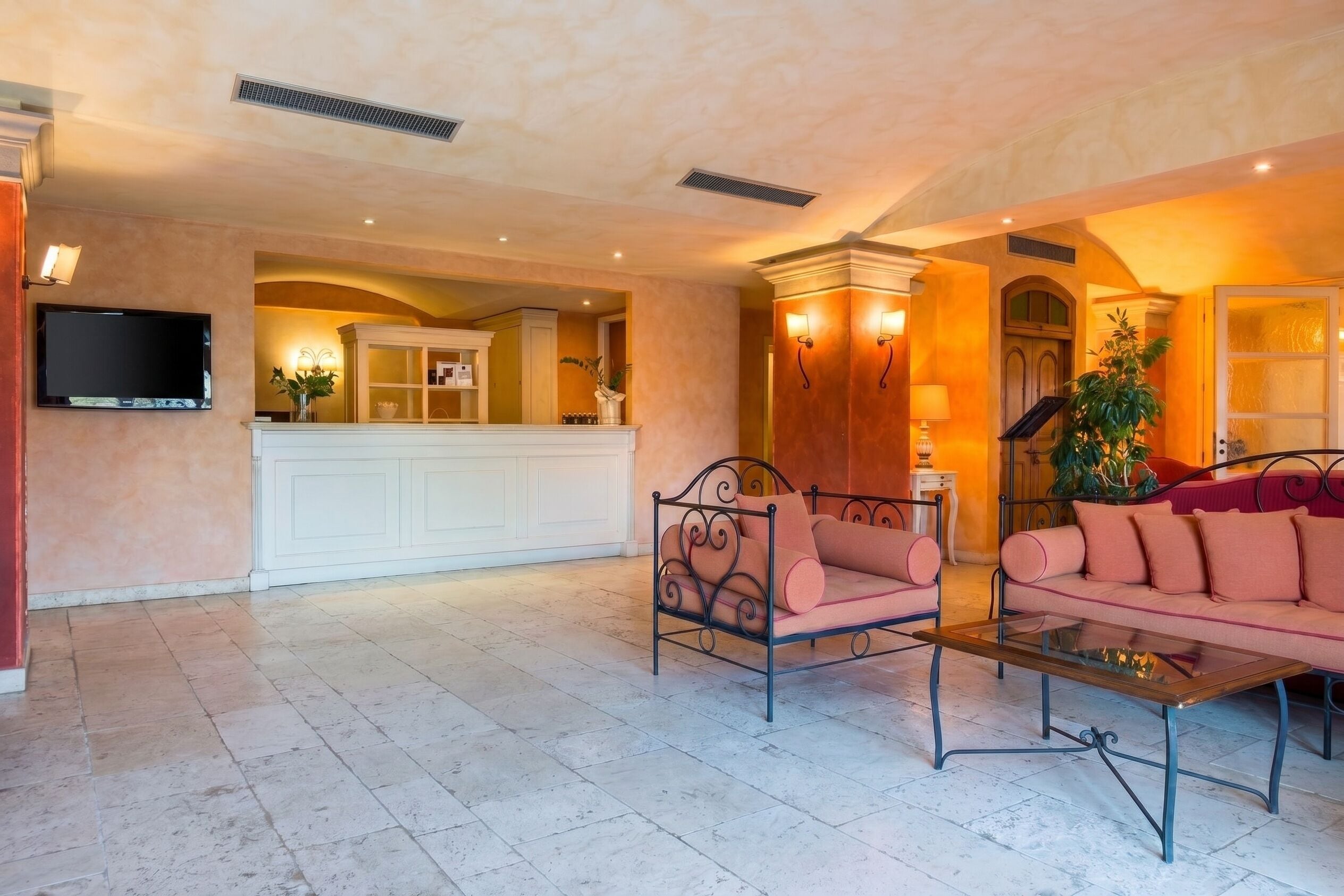 A spacious living area with a sofa, a coffee table, and a television mounted on the wall.