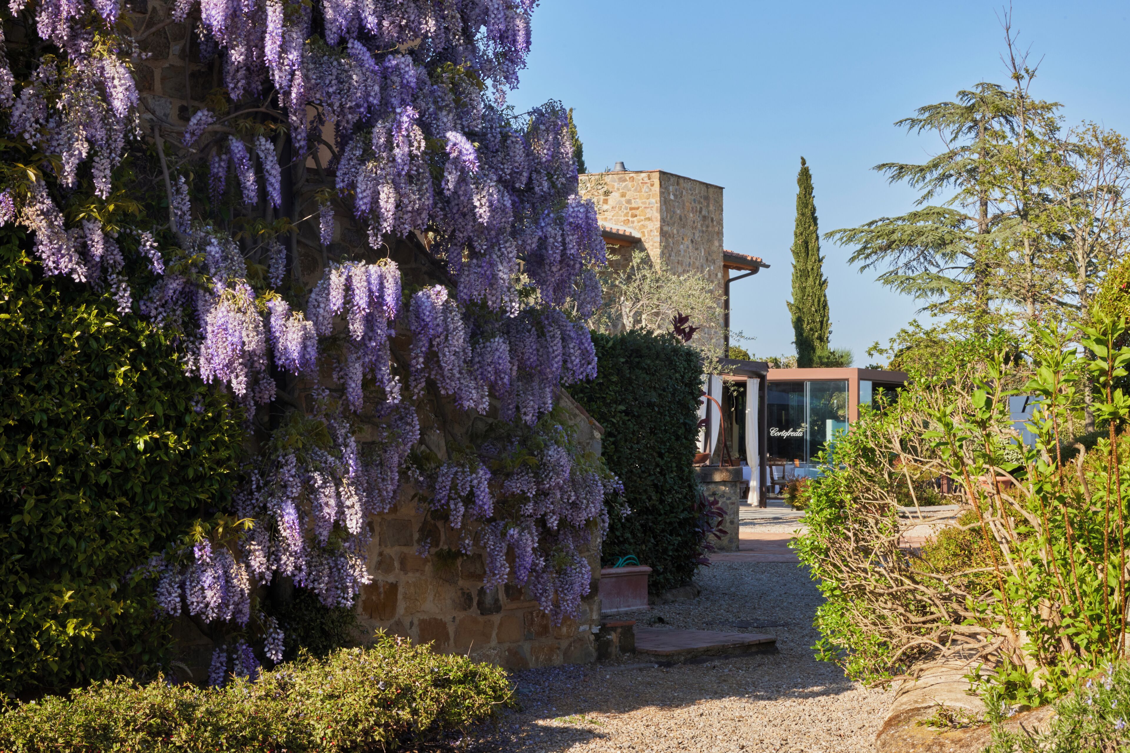 A stone building with a gravel path leading to a glass door entrance.
