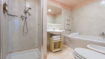 Un baño moderno con ducha envuelta en vidrio, lavabo, bañera y retrete.