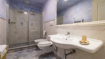 A bathroom with a shower, toilet, and sink.