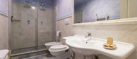 Un baño con ducha, inodoro y lavabo.