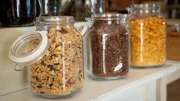 Three glass jars with metal lids on a shelf.