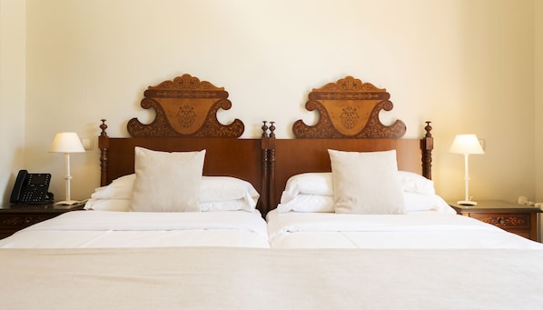 A double bed with a wooden headboard, white bedding, two bedside tables with lamps, and a telephone on the left table. - Hotel Cala Fornells (Calvia)