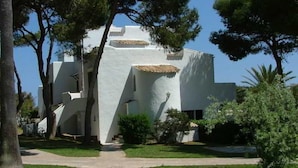 A modern building with a white exterior and a central staircase leading to the entrance. - Apartamentos Parque Mar (Santanyi)