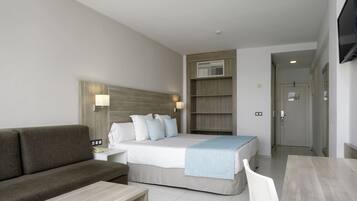 Una habitación de hotel con cama, sofá, escritorio y televisión.