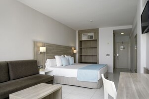 Ett hotellrum med en säng, en soffa, ett skrivbord och en tv.