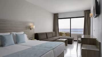 Una habitación de hotel con una cama grande, un sofá, un escritorio y un televisor.