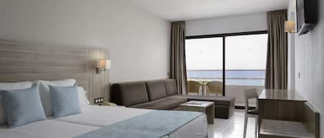 Una habitación de hotel con una cama grande, un sofá, un escritorio y un televisor.