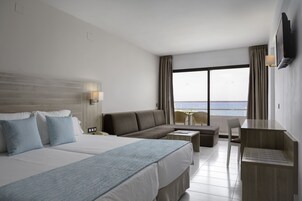 Una habitación de hotel con una cama grande, un sofá, un escritorio y un televisor.