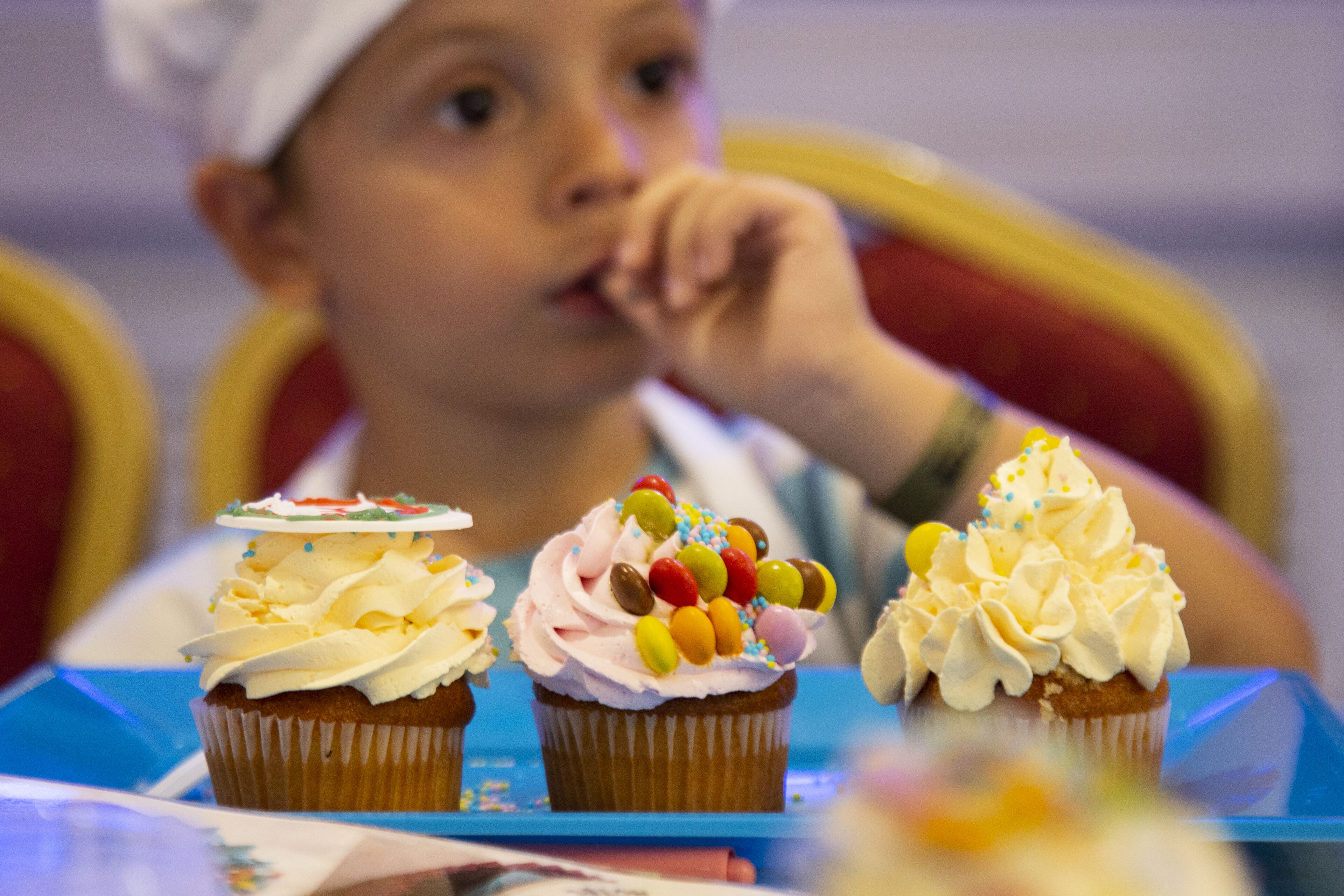 Tres cupcakes con distintos toppings en una bandeja azul.