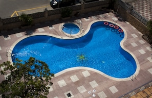 Piscina a l'aire lliure, para-sols i gandules